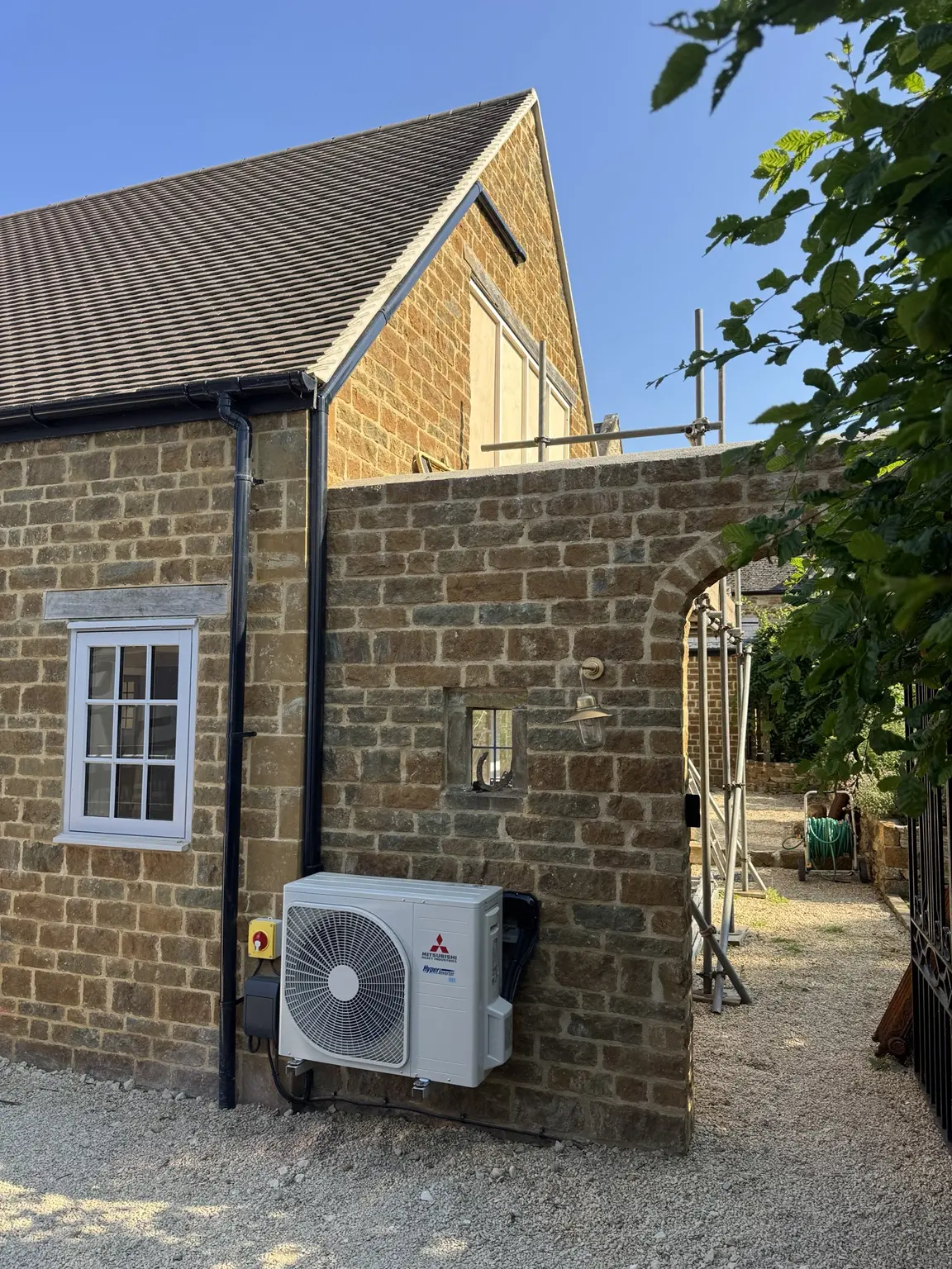Outdoor air conditioning unit installed neatly on a stone property