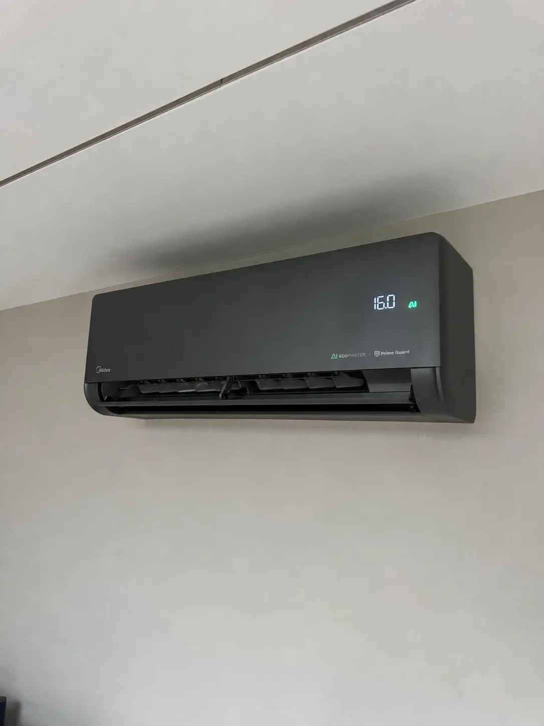 Modern black air conditioning unit installed in a finished room
