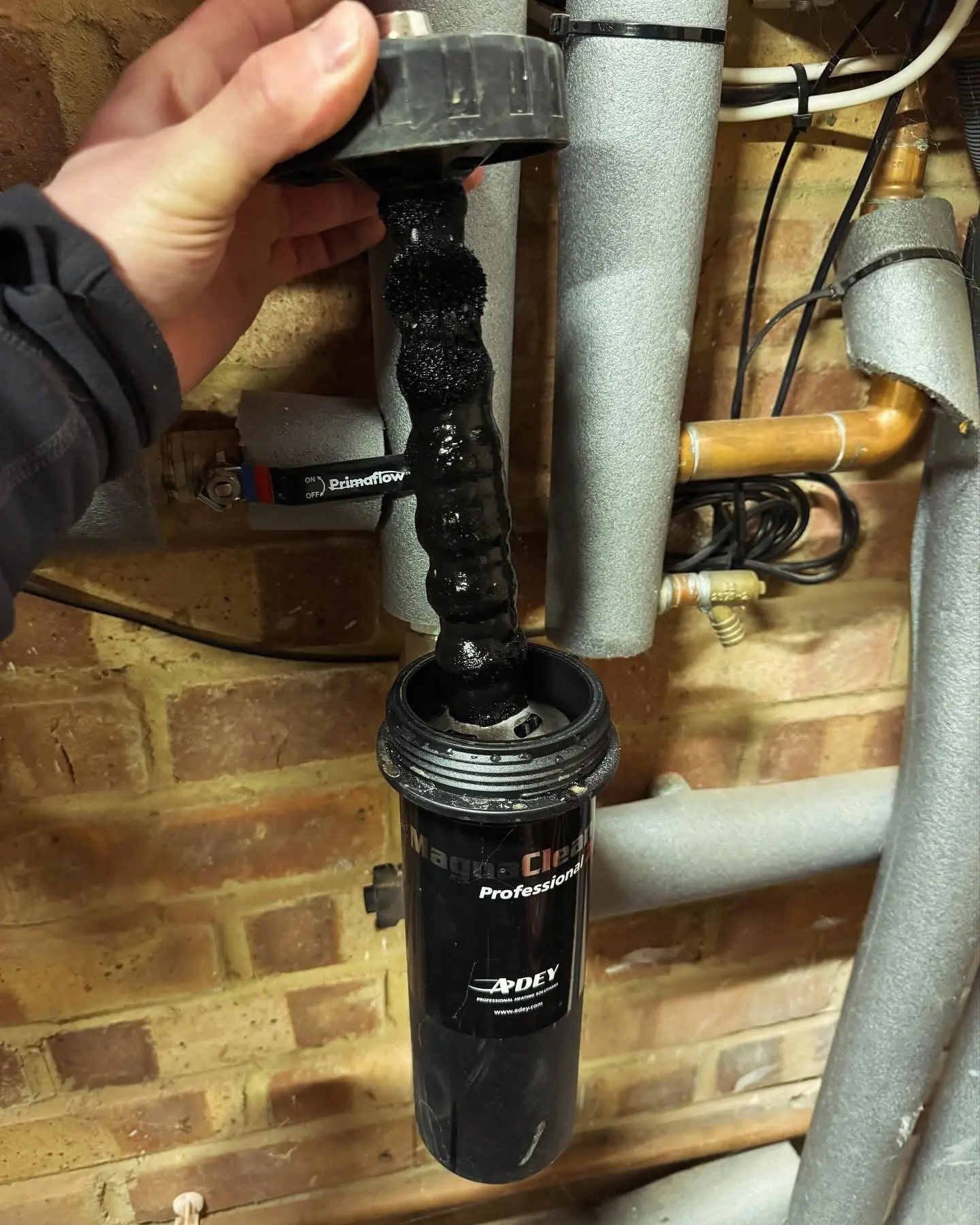 Magnetic heating system filter before cleaning, covered in collected sludge